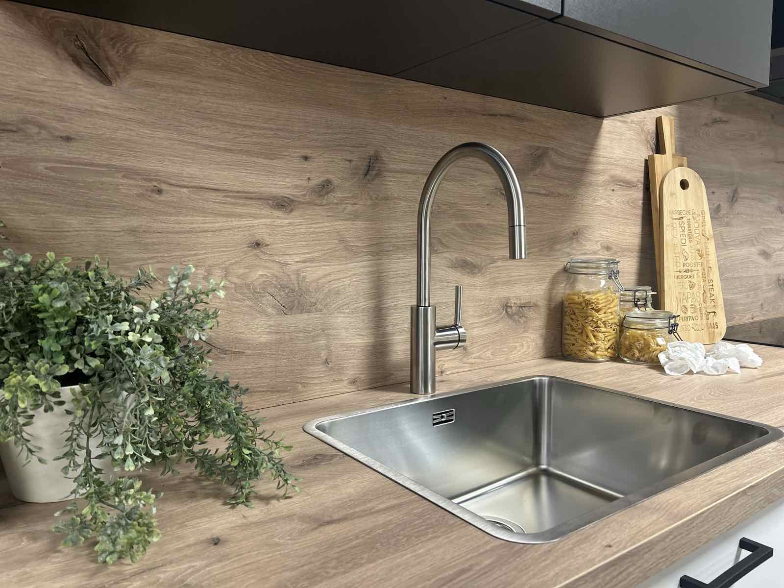 RVS keukenkraan met uittrekbare uitloop boven een RVS onderbouw spoelbak in een eiken keuken